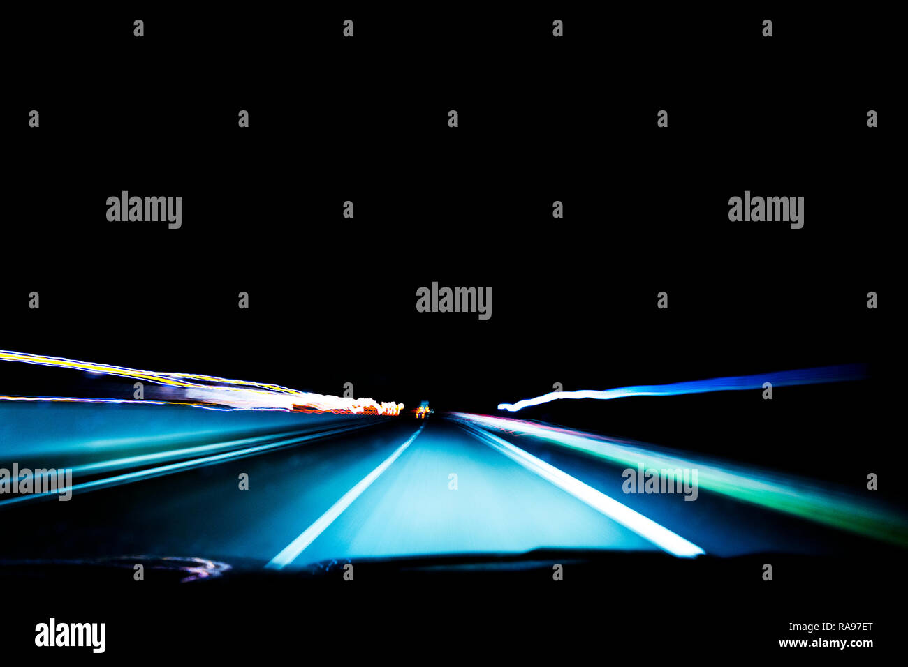 Cars light trails on a curved highway at night. Night traffic trails. Motion blur. Night city road with traffic headlight motion. Cityscape. Light up  Stock Photo