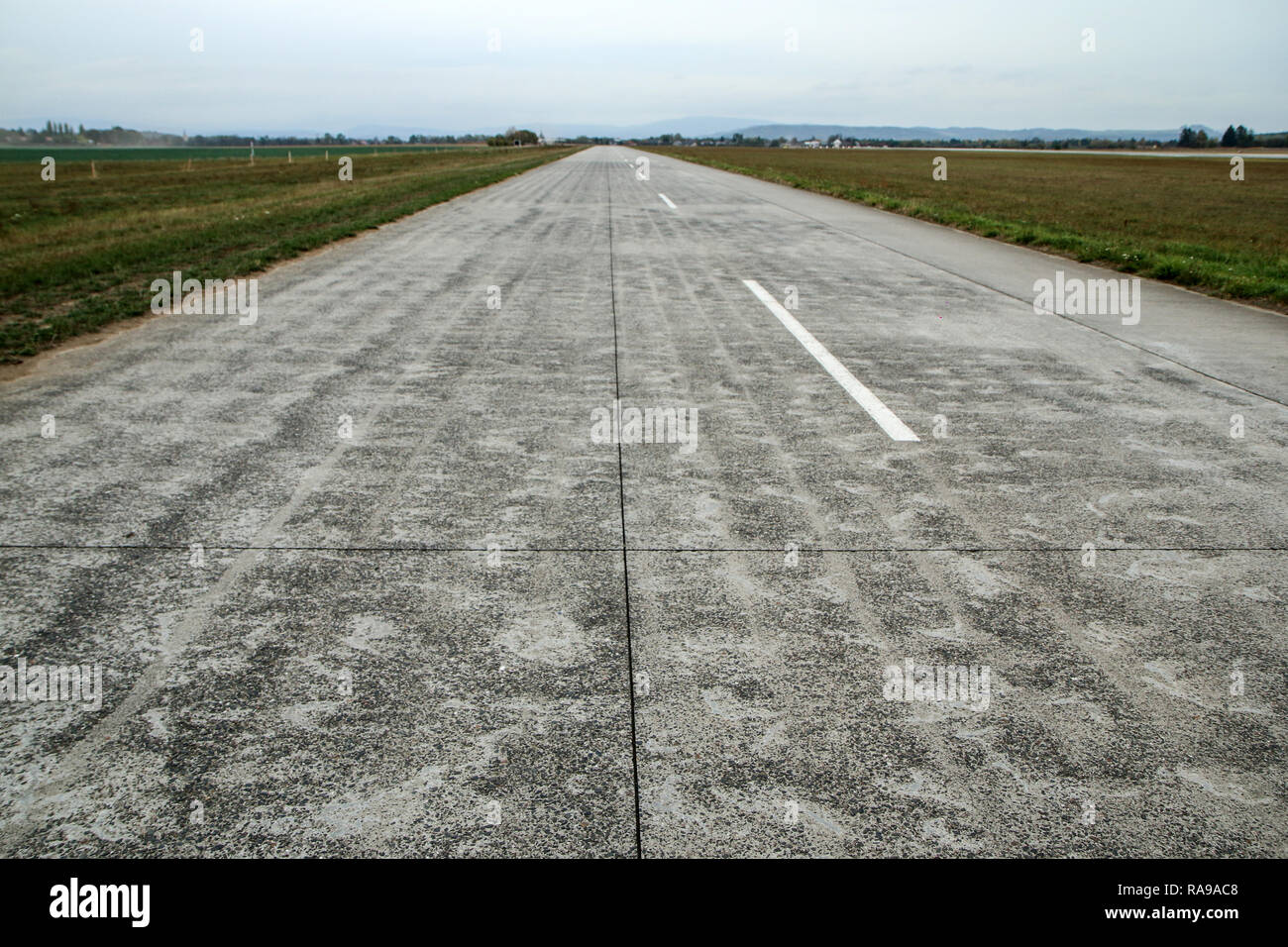 A picture of an empty long old airport runway made from conrcrete panels. Stock Photo