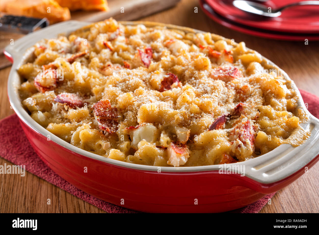 A delicious homemade lobster mac and cheese casserole on a wood table top. Stock Photo