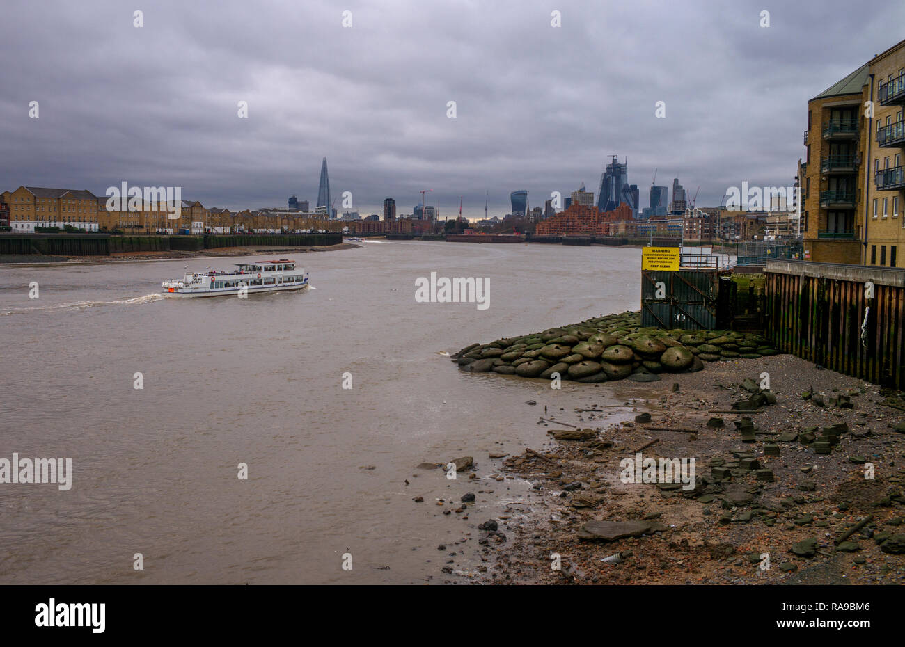 River Thames at low tide, low water. Dec 2018 Looking towards the City of London from tow path at Canary Wharf Stock Photo