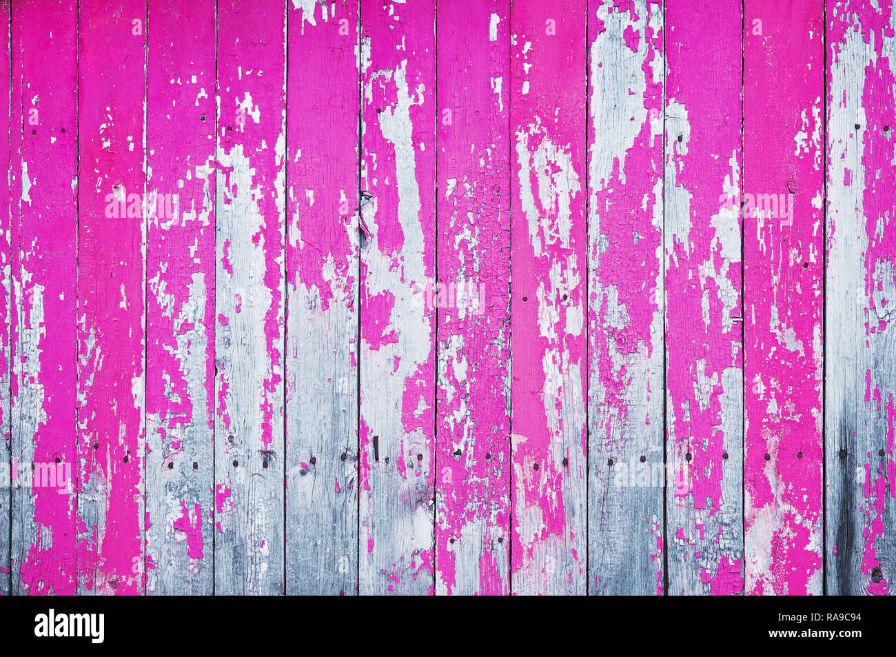 Old cracked wooden board painted with pink paint. Abstract background. Stock Photo
