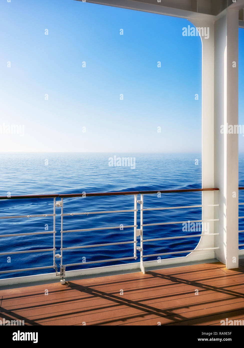 View of the sea and distant horizon over the deck and railing of ship ...