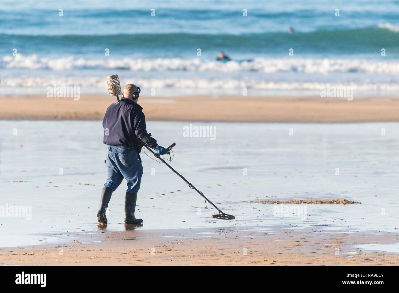 A metal dectorist searching on the beach at Fistral in Newquay in Cornwall. Stock Photo