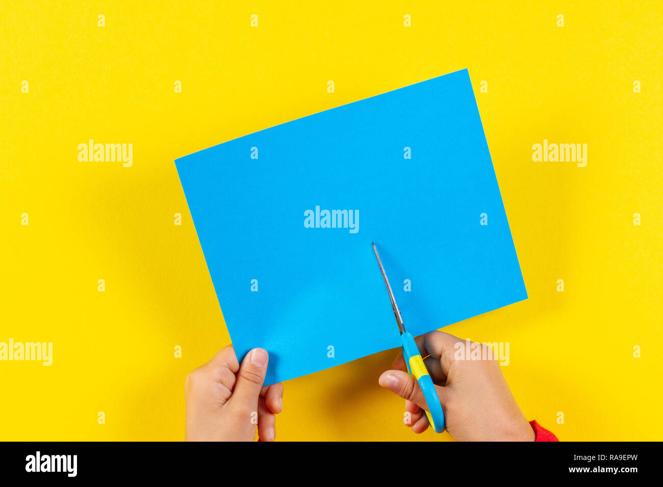 Kid's hands cutting colored paper with scissors Stock Photo Alamy
