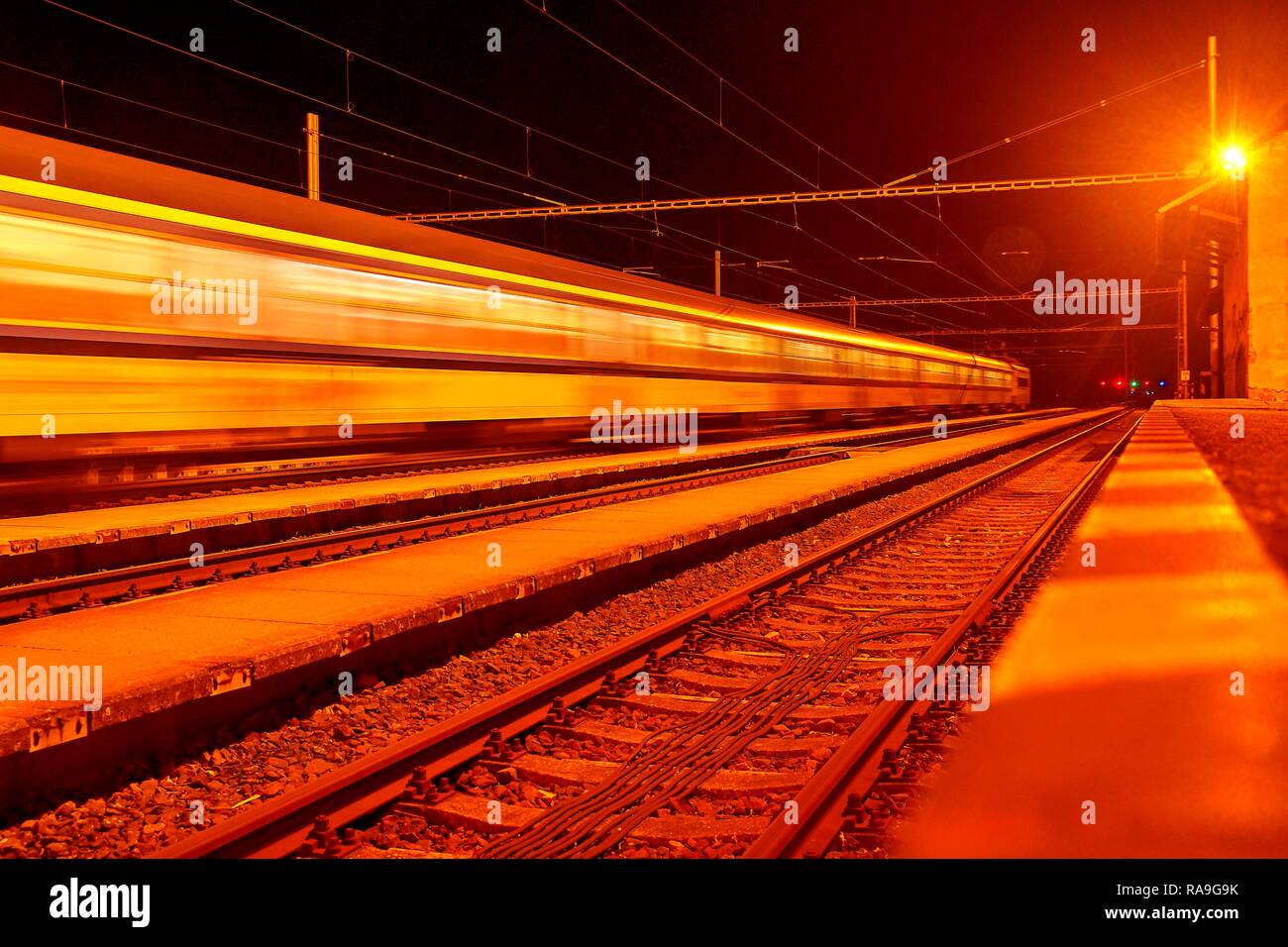 High speed passenger train on tracks with motion blur effect at night ...