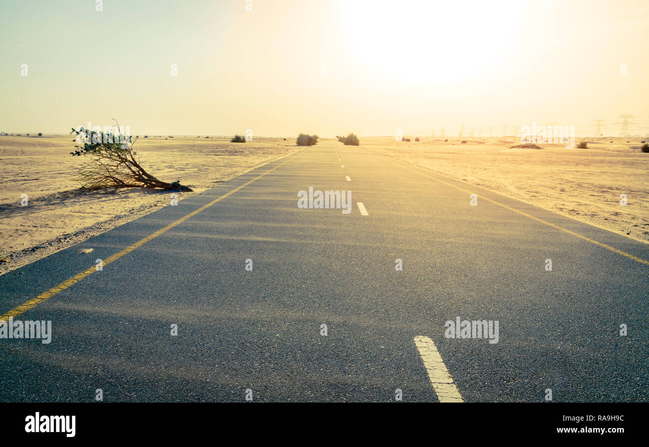 Sand is blowing across a desert road near Dubai in UAE. Stock Photo