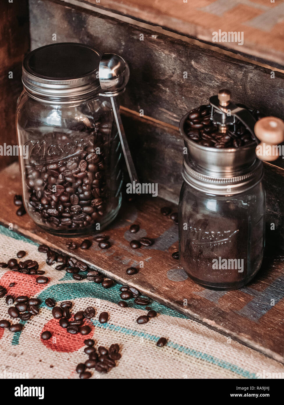 https://c8.alamy.com/comp/RA9JHJ/old-style-coffee-grinder-and-coffee-beans-in-mason-jars-RA9JHJ.jpg