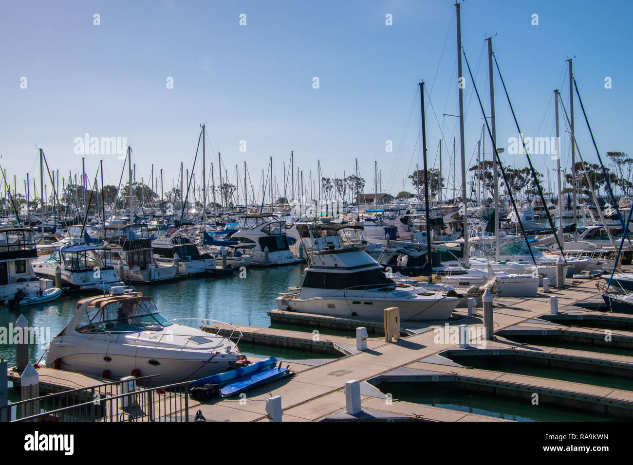 Small marina with deep blue water and many sail and power boats docked in slips Stock Photo