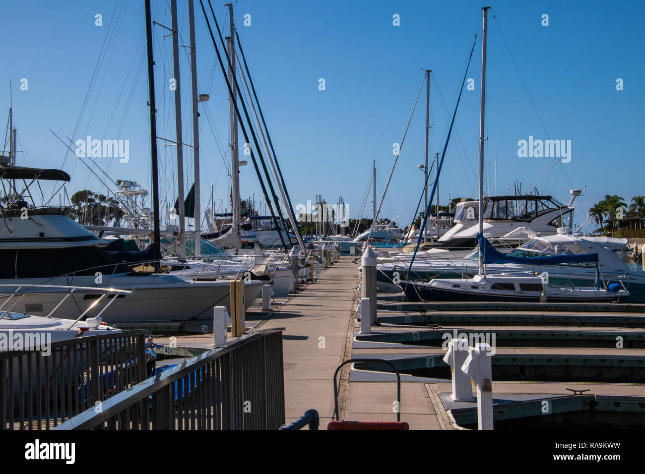 Small marina with deep blue water and many sail and power boats docked in slips Stock Photo