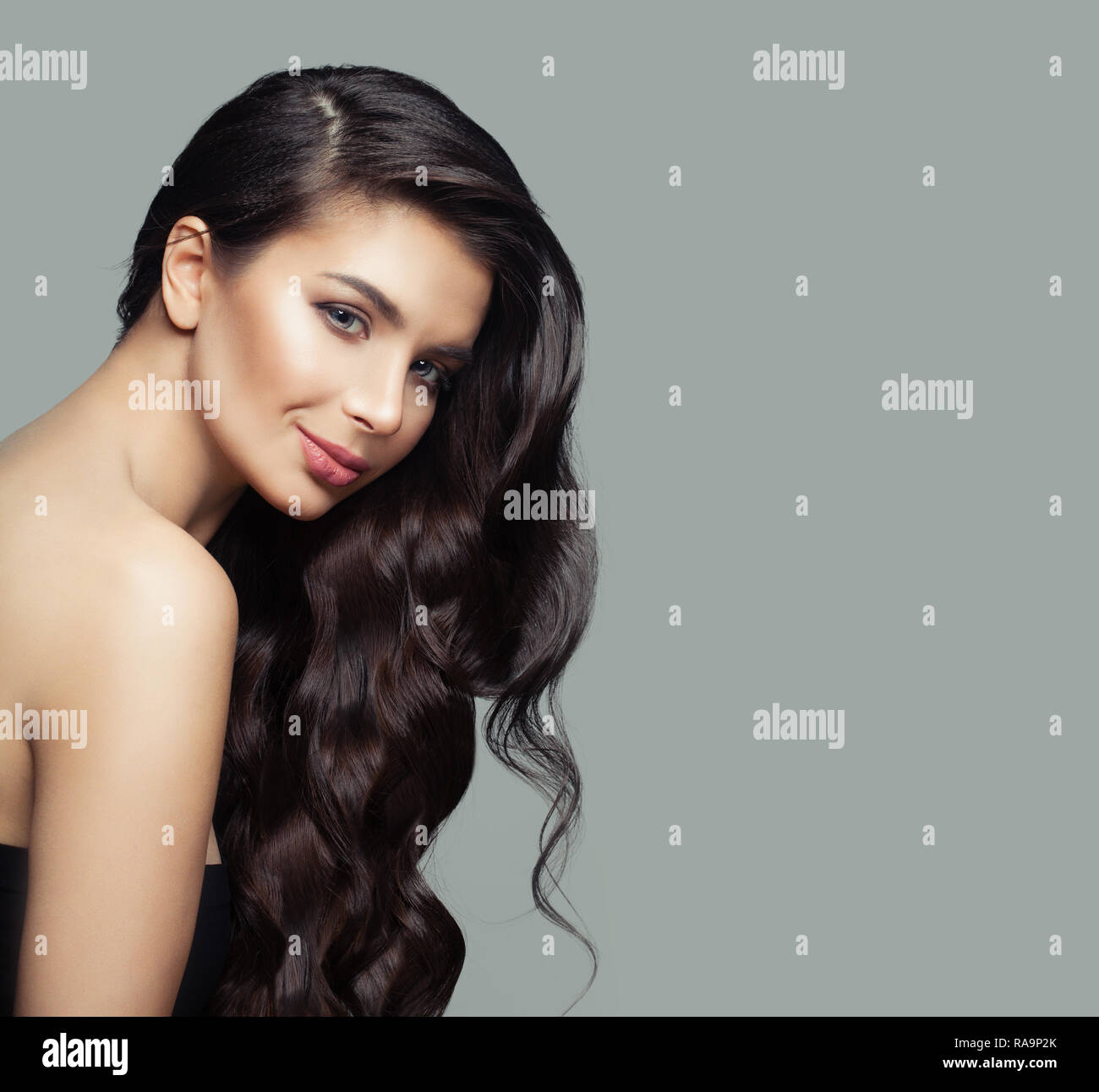 Cheerful woman with dark brown curly hair, haircare and  beauty salon background Stock Photo