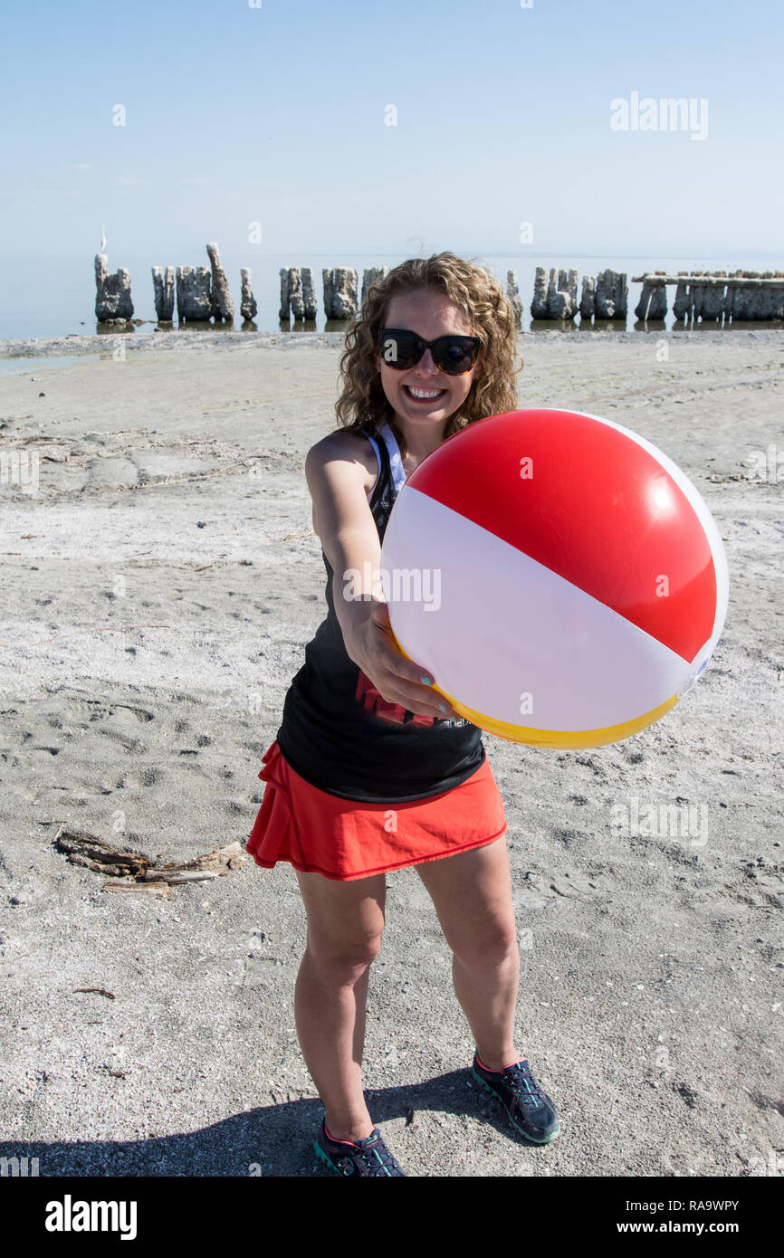 An adult female holds a beach ball in the air at the abandoned Bombay