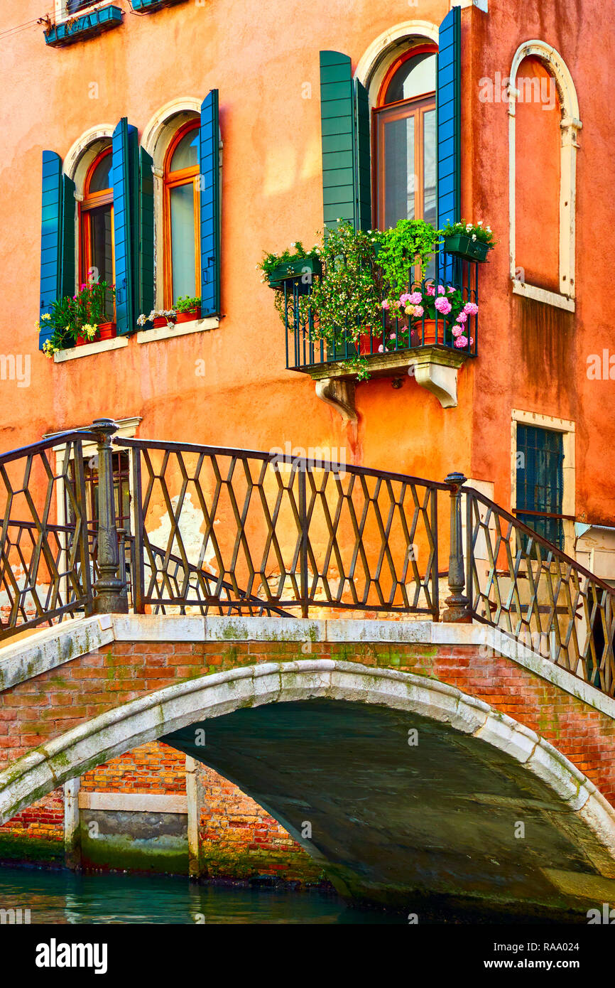 Old small bridge and old houses by canal in Venice, Italy Stock Photo