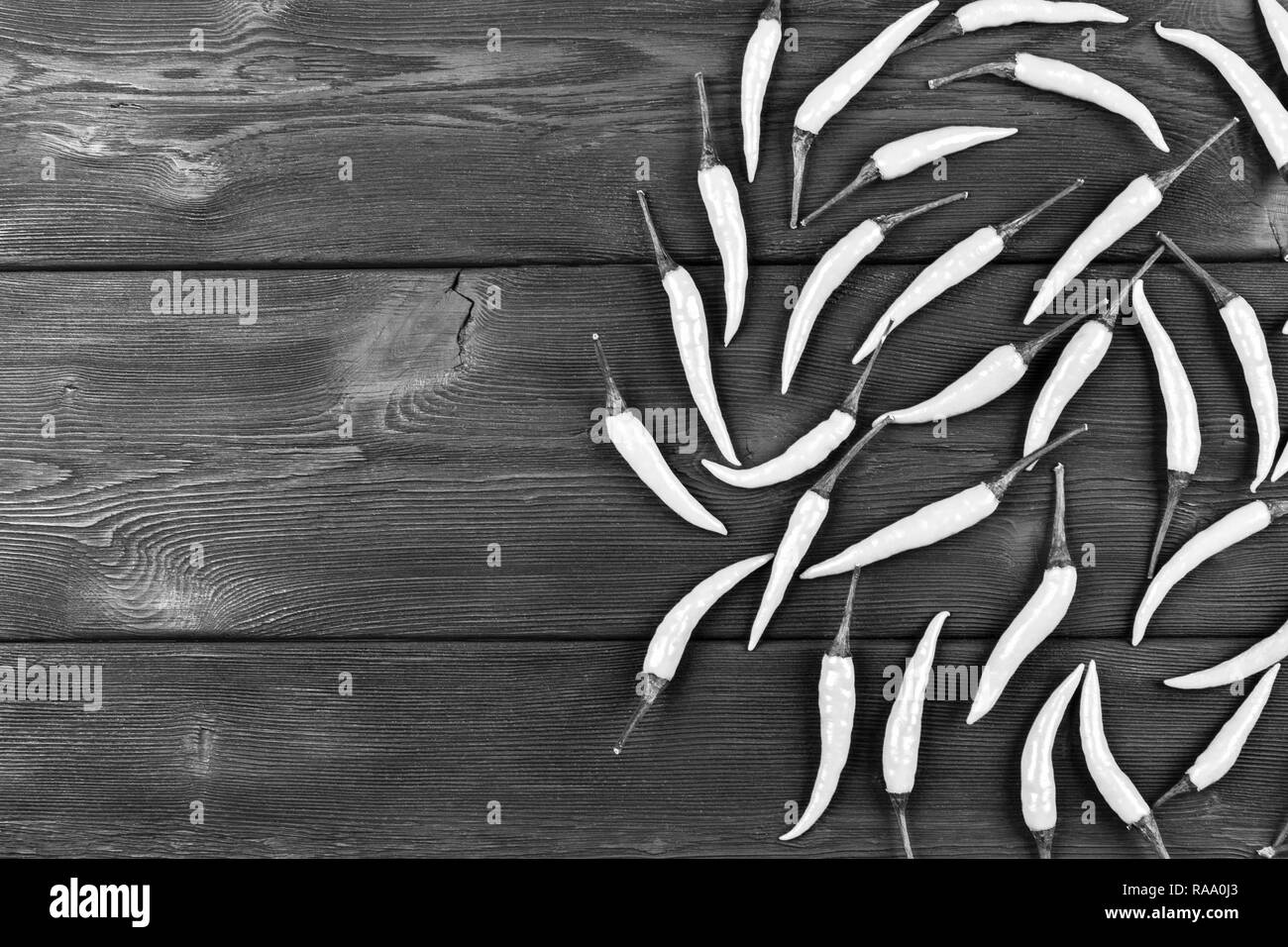 Red chili pepper on the dark wood table background. Black and white Stock Photo
