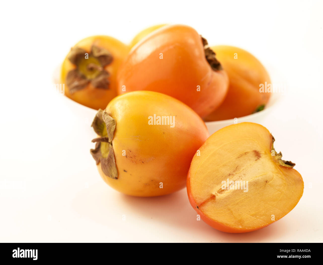 Sharon fruit against white background, food portrait Stock Photo - Alamy