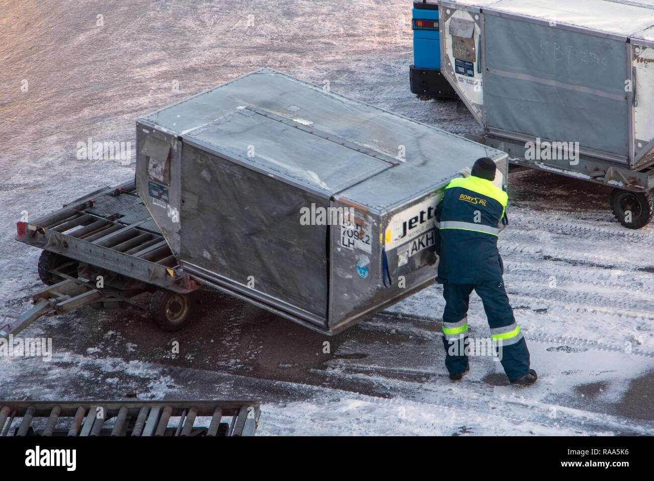KIEV, UKRAINE, NOV 28 2018, A ground staff of the airport manipulate the freight container. Stock Photo