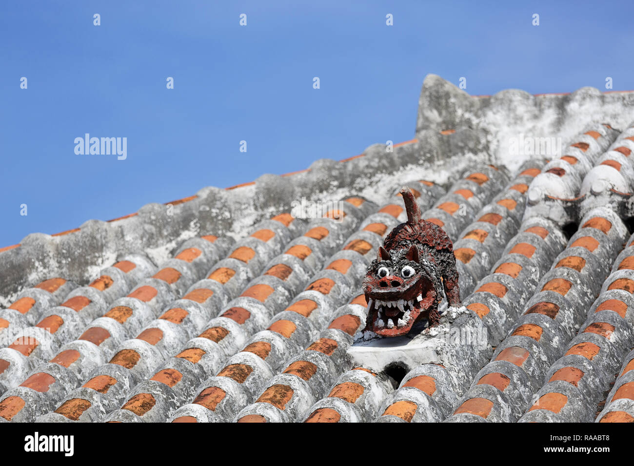Shisa lion atop traditional tile roof to protect the house from the bad spirits, Yaeyama Islands, Taketomi island, Japan Stock Photo