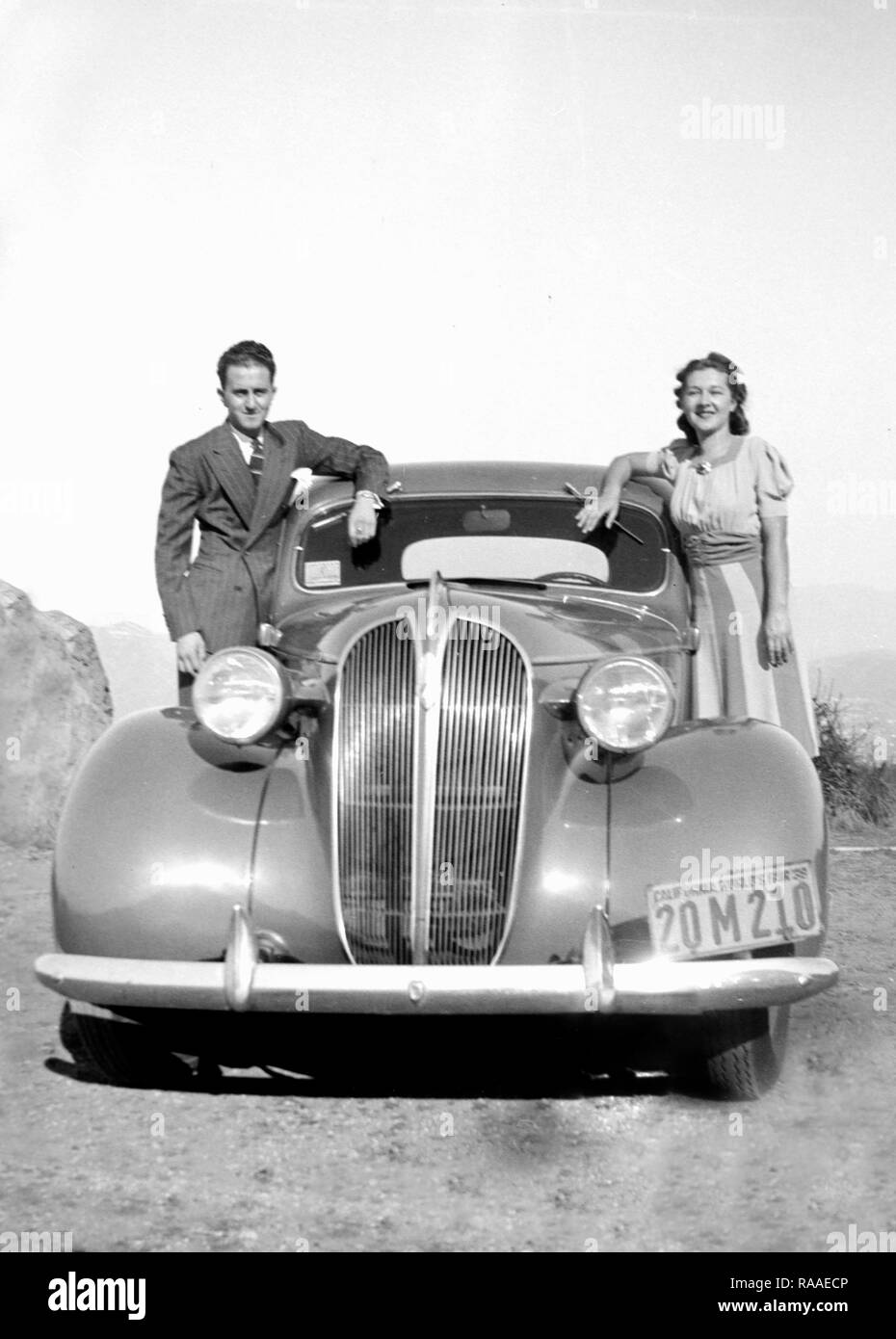 A young couple proudly pose by their new automobile, ca. 1938. Stock Photo