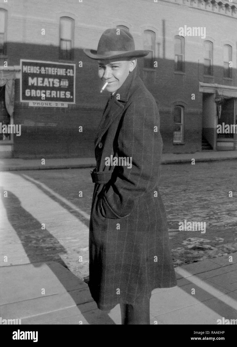 A young man smiles crossing a street in Salida, Colorado, ca.1928. Stock Photo