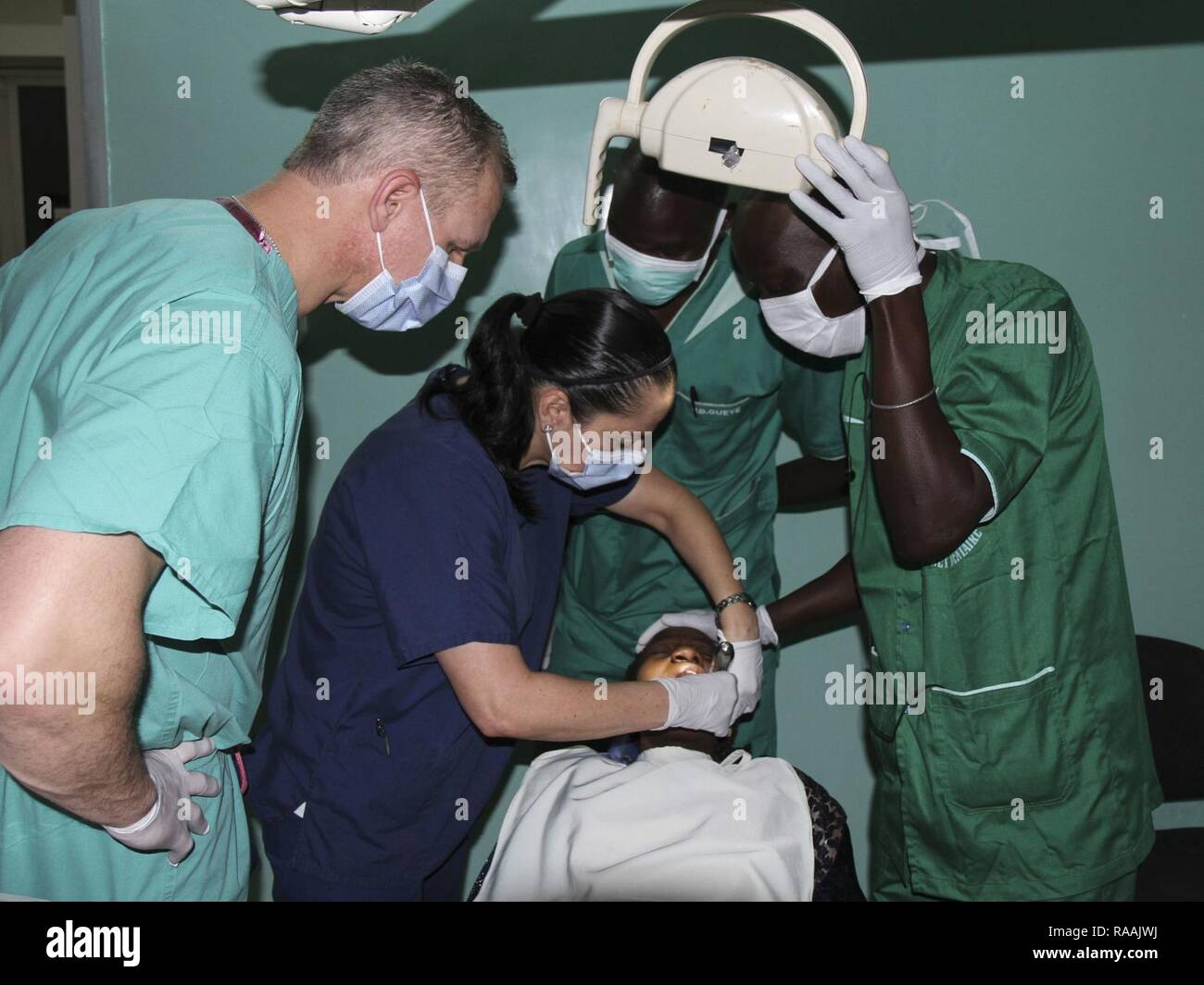 A team of U.S. military and Senegalese medical professionals examine a dental patient during Medical Readiness Training Exercise 17-1 at La Sante des Armees Hospital in Dakar, Senegal, Jan. 12, 2017. MEDRETE is a combined effort between the Senegalese government, U.S. Army Africa, the U.S. Army Reserve 332nd Medical Brigade in Nashville, Tenn., and the Vermont Air National Guard. AFRICOM’s MEDRETEs hosted by United States Army-Africa pair small teams of military medical professionals from the U.S. with participating African partner nations to train alongside and share best practices in trauma  Stock Photo