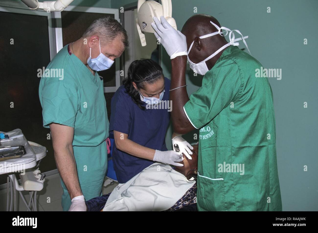 A team of U.S. military and Senegalese medical professionals examine a dental patient during Medical Readiness Training Exercise 17-1 at La Sante des Armees Hospital in Dakar, Senegal, Jan. 12, 2017. MEDRETE is a combined effort between the Senegalese government, U.S. Army Africa, the U.S. Army Reserve 332nd Medical Brigade in Nashville, Tenn., and the Vermont Air National Guard. AFRICOM’s MEDRETEs hosted by United States Army-Africa pair small teams of military medical professionals from the U.S. with participating African partner nations to train alongside and share best practices in trauma  Stock Photo