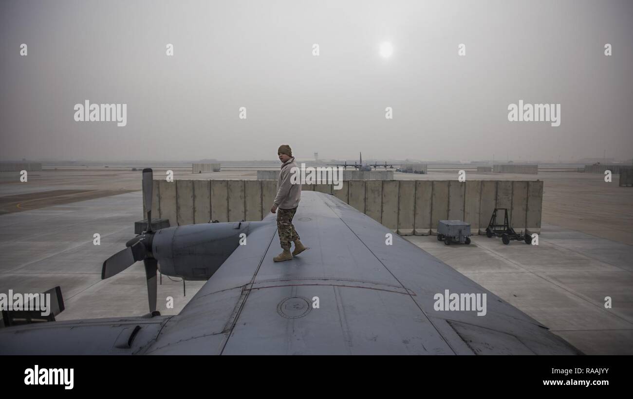Staff Sgt. Sean Nelson, 455th Expeditionary Aircraft Maintenance Squadron crew chief, walks along the wing of an EC-130 Compass Call Jan. 18, 2017 at Bagram Airfield, Afghanistan. In the past four months, the unit has flown more than any other time of the same period in the history of the unit. Stock Photo
