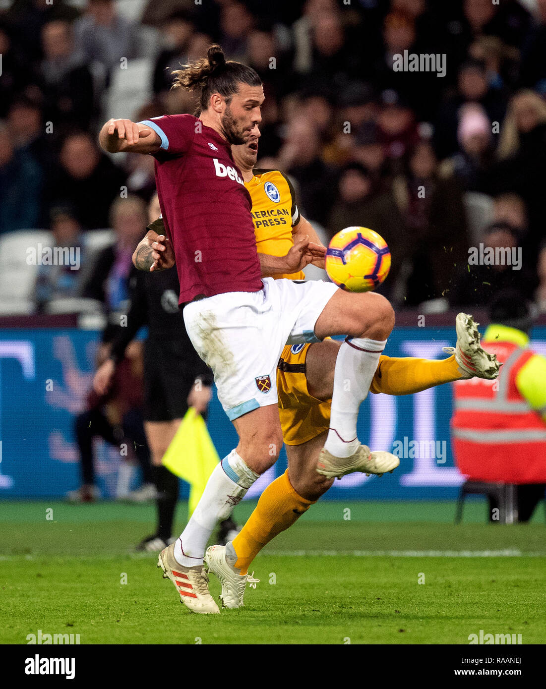 West Ham United's Andy Carroll (left) and Brighton & Hove Albion's Lewis Dunk battle for the ball during the Premier League match at the London Stadium. Stock Photo