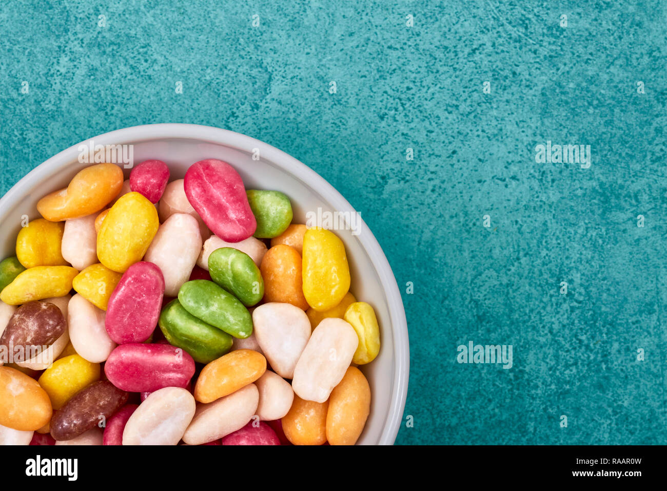 Colorful candies in a bowl, space for text. Stock Photo