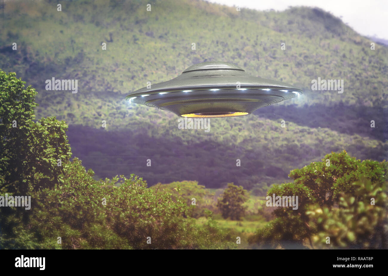 Unidentified flying object over a forest with trees and mountains behind. Old style photo with high ISO noise and dirt with scratches over time. Stock Photo