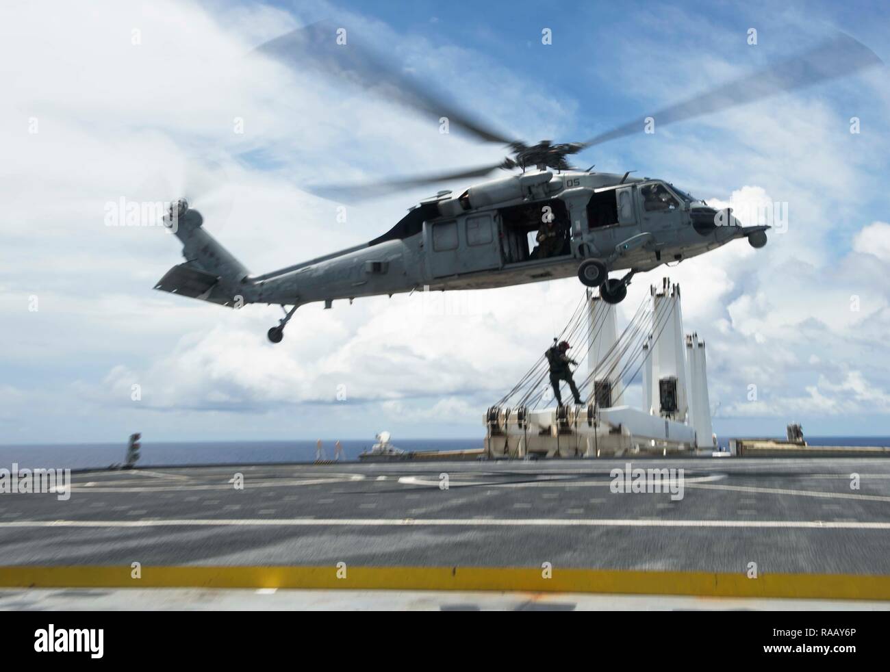 PACIFIC OCEAN (August 23, 2018) - Naval Air Crewman (Helicopter) 2nd Class Jacob Ward, acting crew chief and rescue swimmer assigned to Helicopter Sea Combat Squadron 25 (HSC-25), lowers Hospital Corpsman 2nd Class Kyle Bowen, a search and rescue medical technician assigned to HSC-25, onto the flight deck of the Watson-class vehicle cargo ship USNS Dahl (T-AKR-312) from HSC-25 MH-60S Seahawk helicopter during a medical evacuation drill, August 23. HSC 25 is the Navy’s only forward deployed MH-60S expeditionary squadron. As a part of Helicopter Sea Combat Wing Pacific, it provides an armed heli Stock Photo