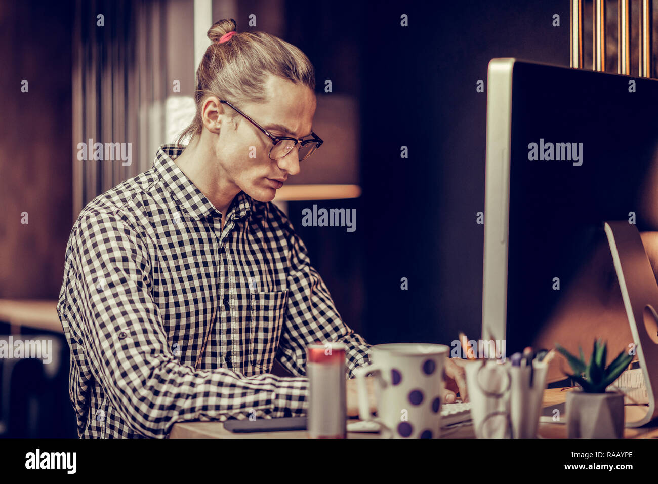 Concentrated male person typing text on his computer Stock Photo