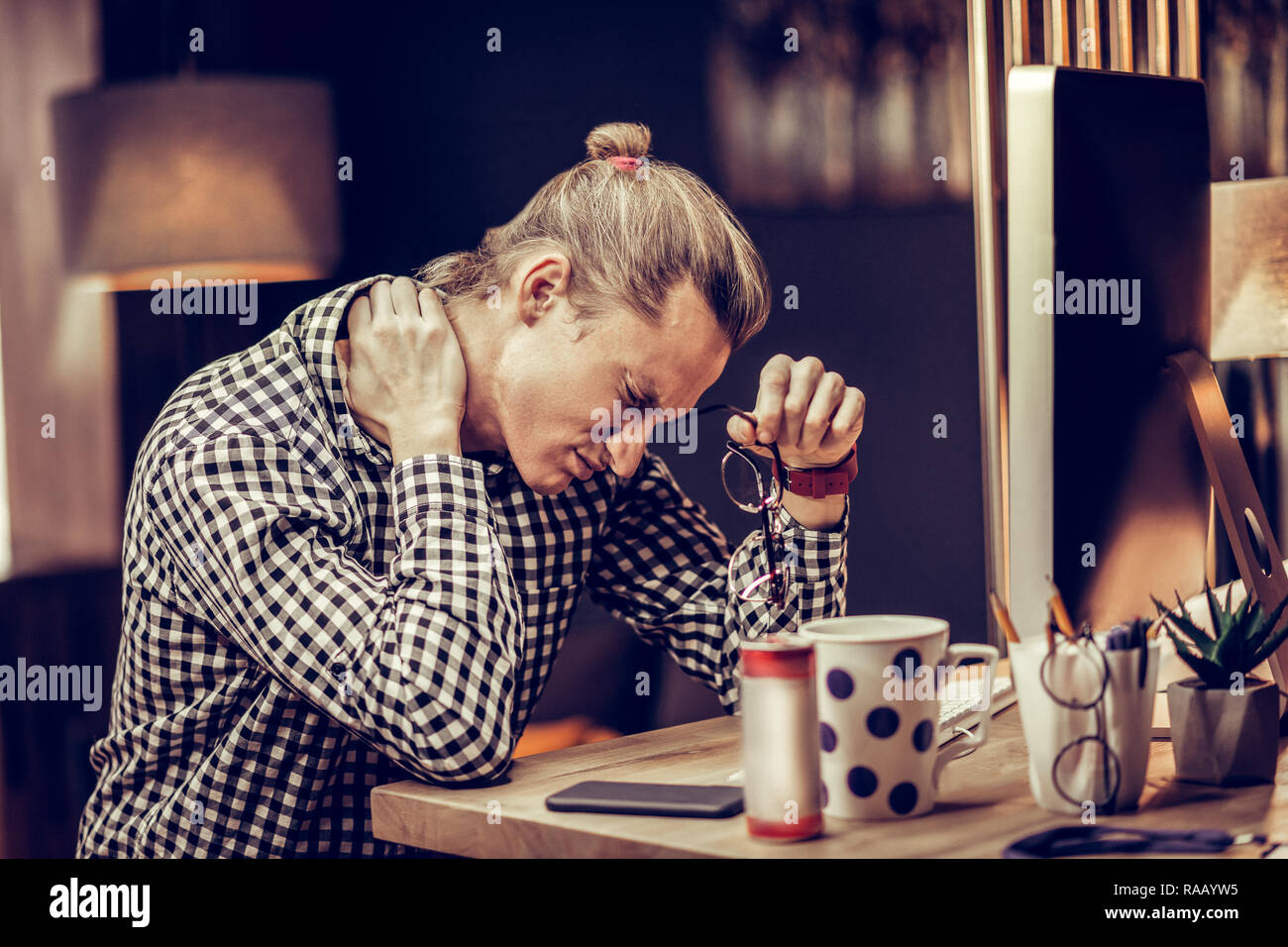Tired young office worker suffering pain in neck Stock Photo - Alamy