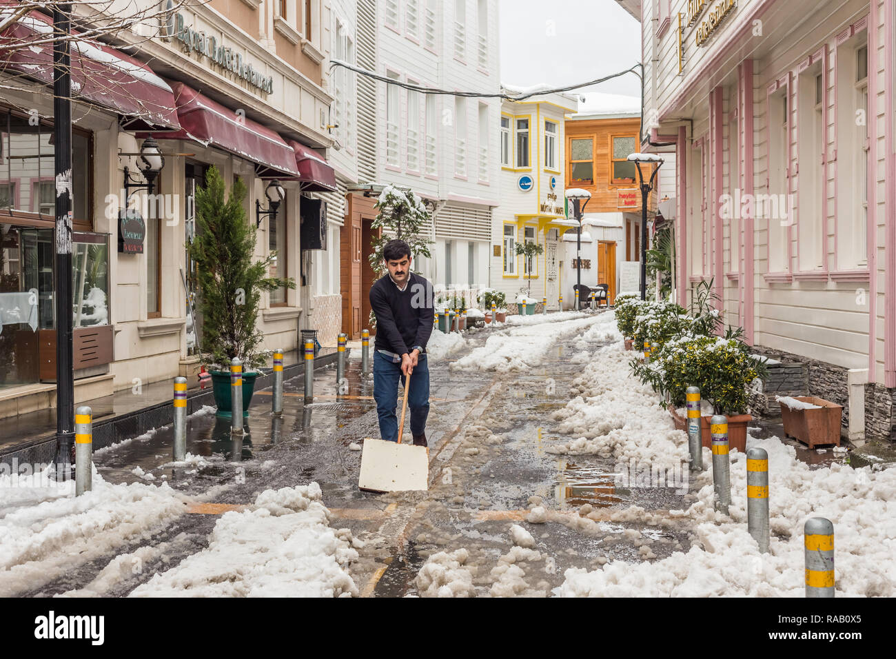 Istanbul, Turkey, February 19, 2015: Turkish man clearing the sonow outside a restaurant in Eyup District. Stock Photo