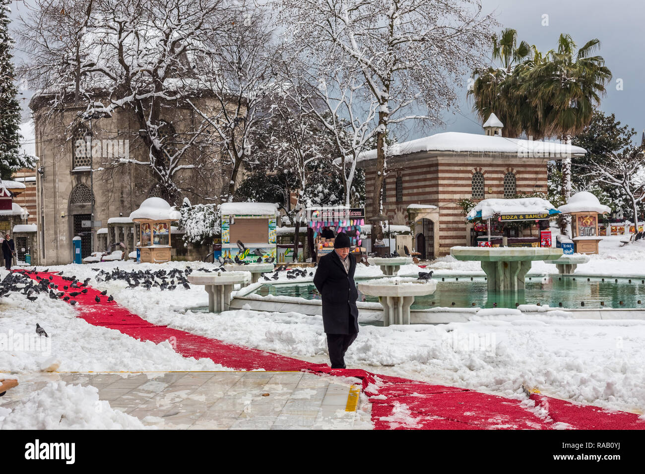 Istanbul, Turkey, February 19, 2015: Turkish man crossing the snow covered Eyup square. Stock Photo