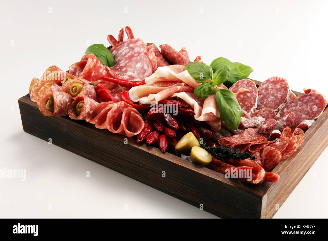 Food tray with delicious salami, pieces of sliced prosciutto crudo