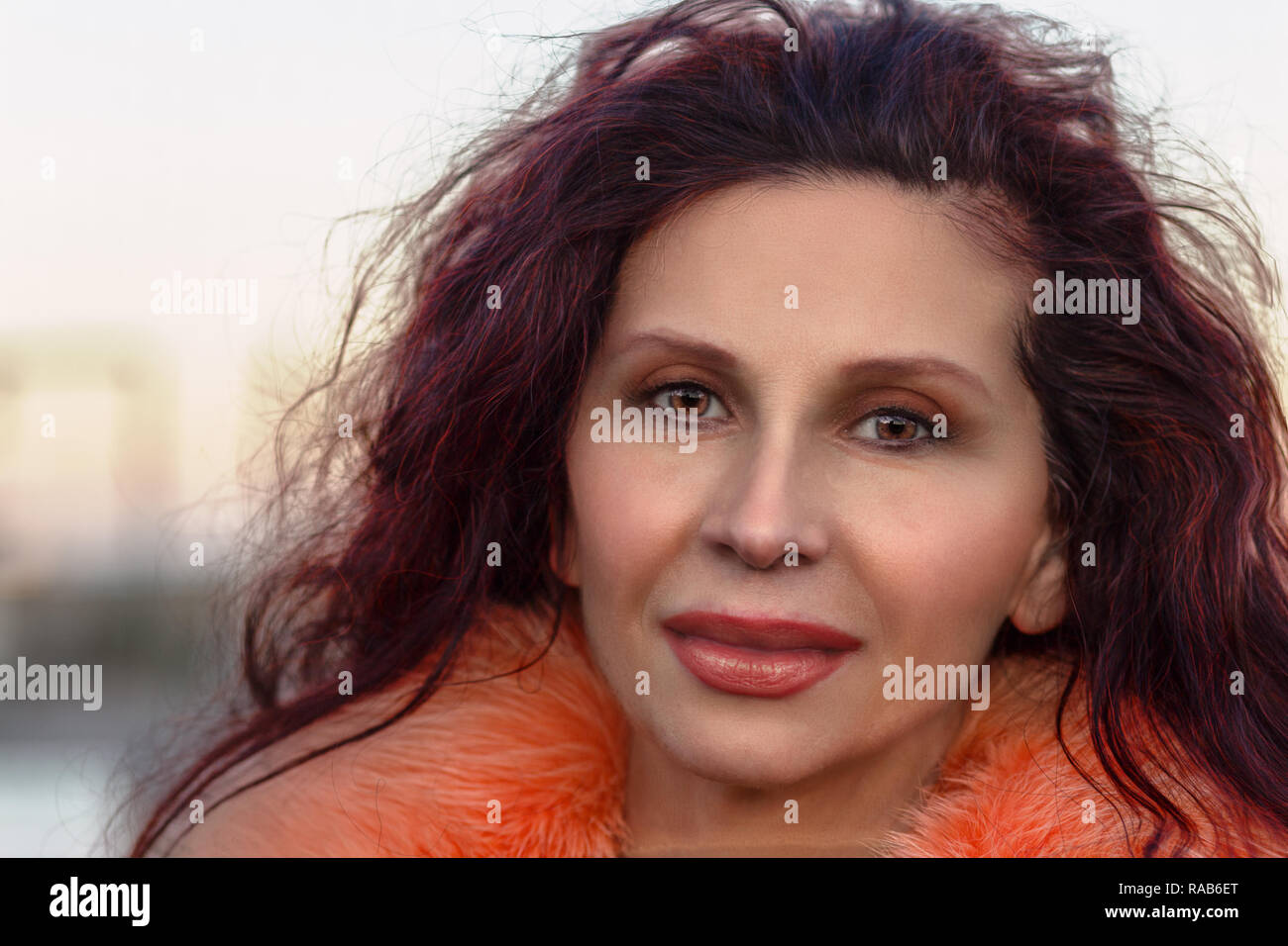 smiling mature woman with orange fur Stock Photo