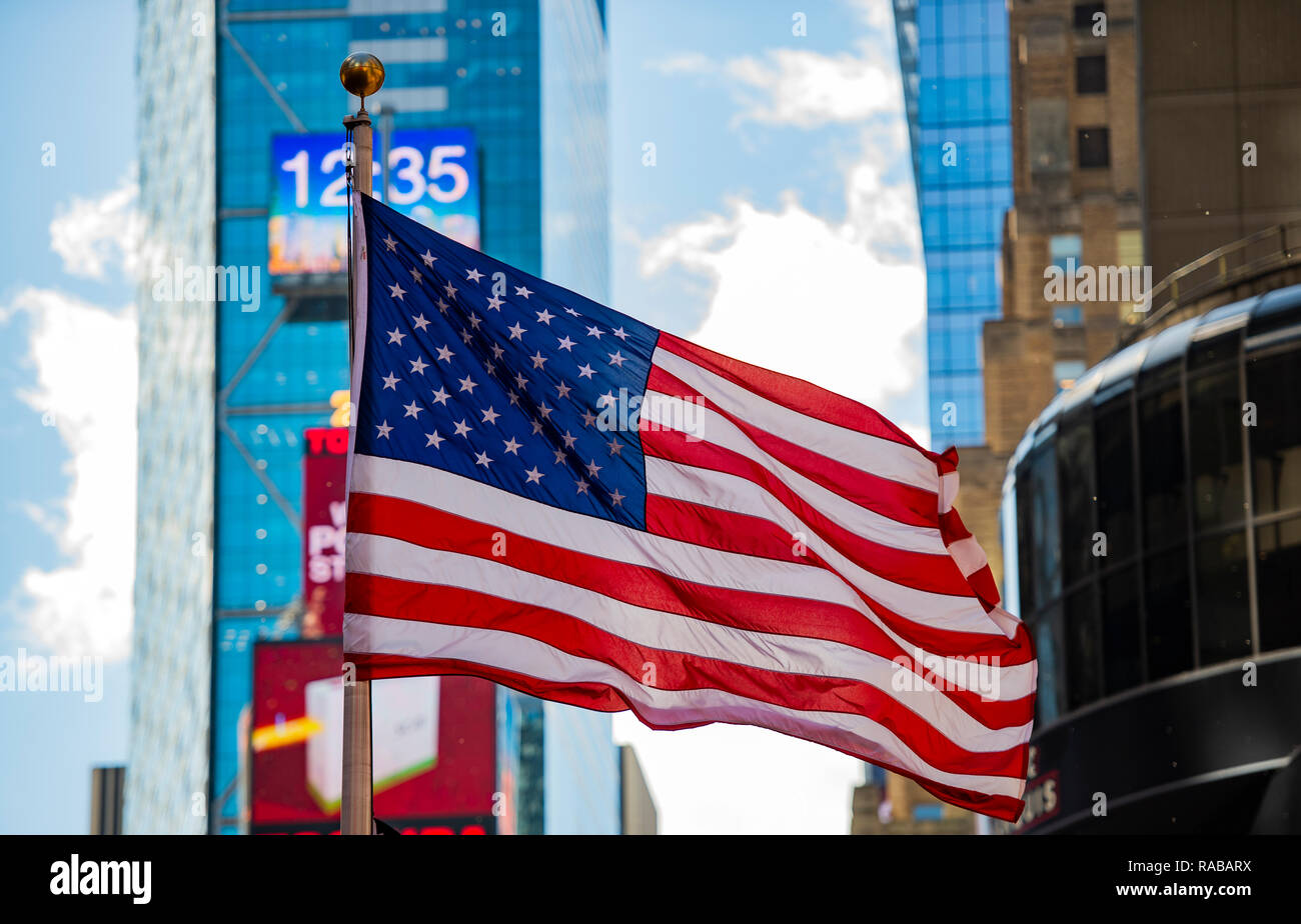 Close-up view of an American flag waving in Times Square in Manhattan. Blurred skyscrapers in the background. New York City, USA. Stock Photo