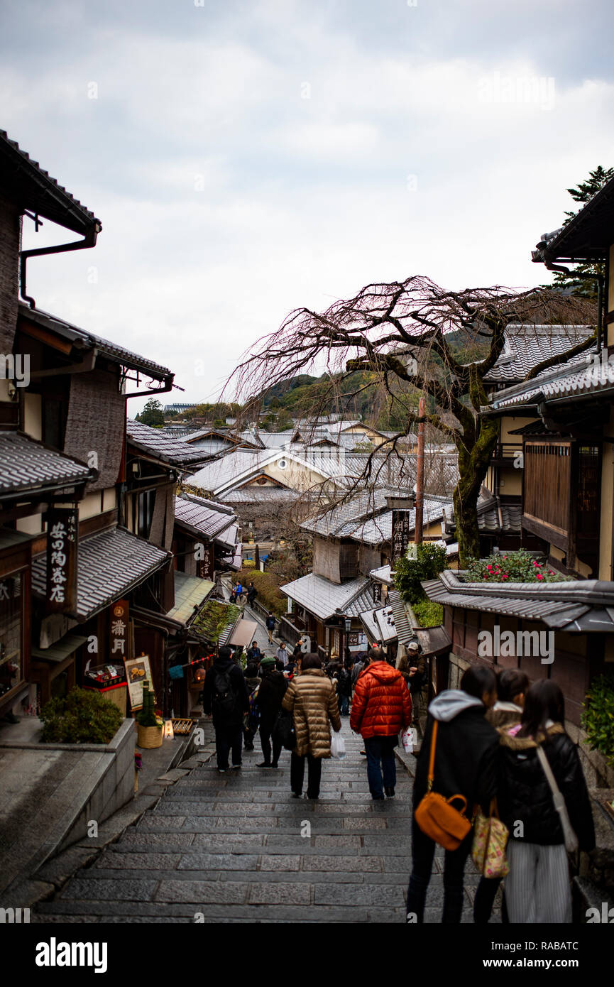 Tourists and Japanese women in traditional kimono walking together to historic Kiyomizu-dera Temple in Kyoto, showing authentic cultural participation