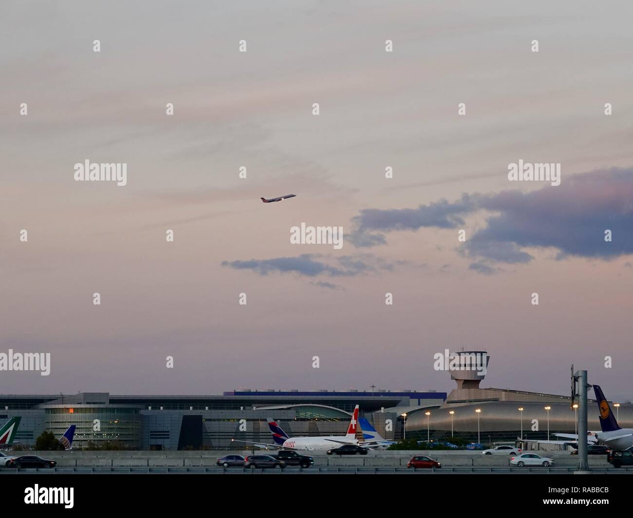 Airplane on takeoff above the Miami International Airport at dusk with Swiss Air jet in foreground, Miami, Florida, USA. Stock Photo