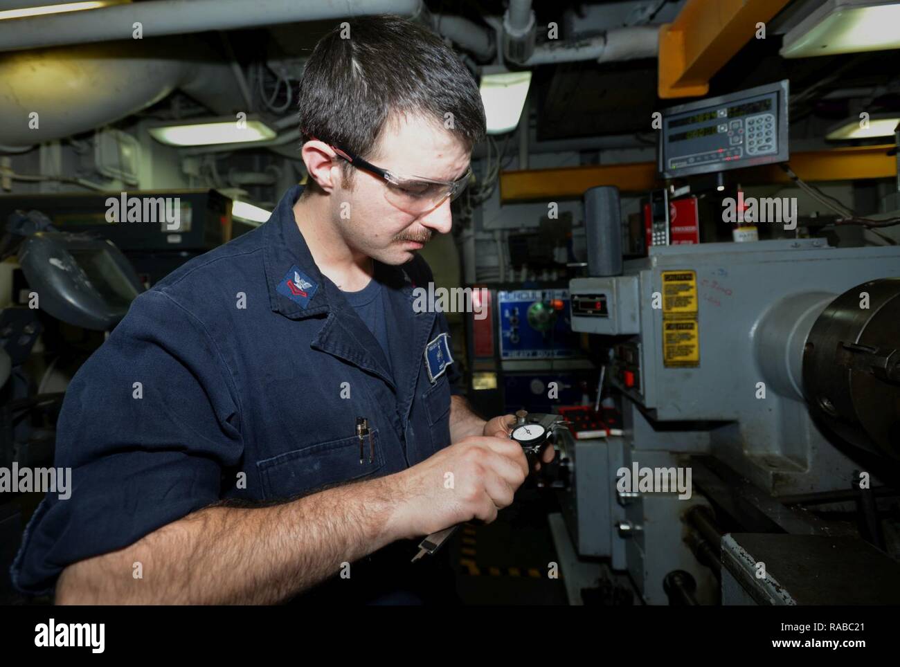 ATLANTIC OCEAN (Jan. 13, 2017) – Machinery Repairman 2nd Class Tim Grover, a native of Hillsboro, Oregon, measures the size of a newly cut shaft in the Machine Shop aboard the Wasp-class multipurpose amphibious assault ship USS Bataan (LHD 5). Bataan is underway conducting Composite Training Unit Exercise (COMPTUEX) with the Bataan Amphibious Ready Group in preparation for an upcoming deployment. Stock Photo