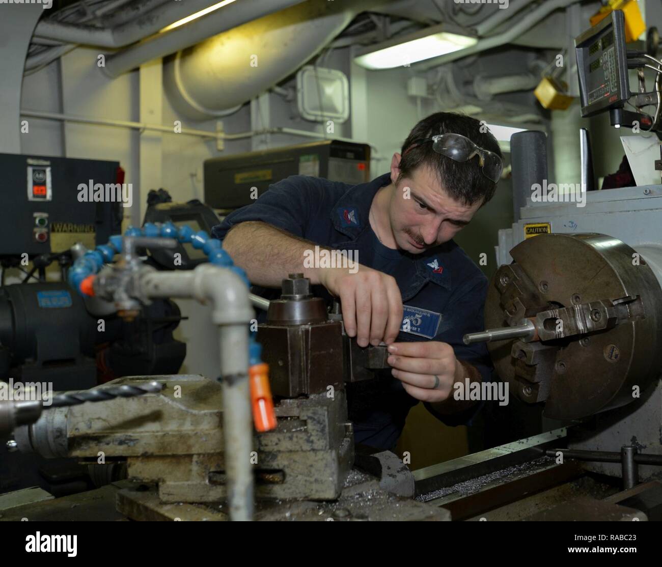 ATLANTIC OCEAN (Jan. 13, 2017) – Machinery Repairman 2nd Class Tim Grover, a native of Hillsboro, Oregon, removes a bolt for cleaning from the cutter in the Machine Shop aboard the Wasp-class multipurpose amphibious assault ship USS Bataan (LHD 5). Bataan is underway conducting Composite Training Unit Exercise (COMPTUEX) with the Bataan Amphibious Ready Group in preparation for an upcoming deployment. Stock Photo