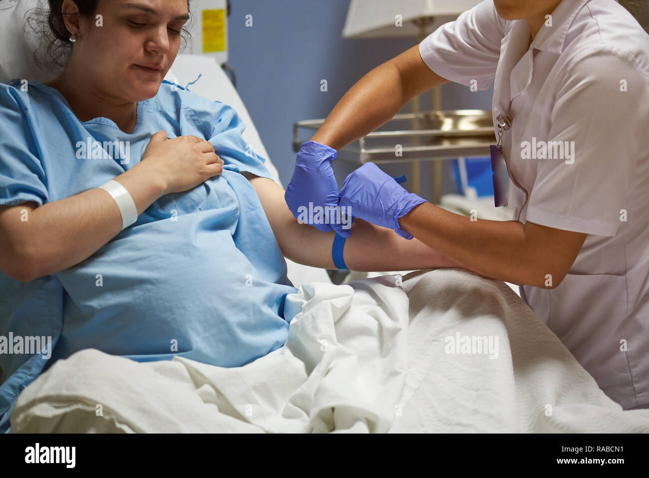 Doctor taking care of woman patient in hospital room Stock Photo