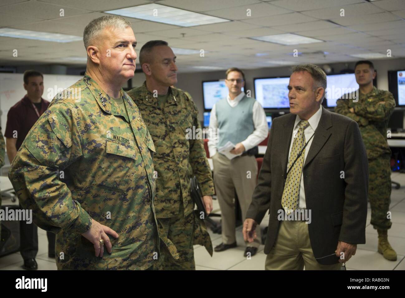 U.S. Marine Corps Gen. Glenn Walters, left, Assistant Commandant of the Marine Corps, speaks with Joe Purcell, director of Training Support Division, Marine Corps Installations-East, in regards to simulator training systems during a visit to Camp Lejeune, N.C., Jan. 26, 2017. The purpose of the visit was to increase awareness and capabilities of ground simulation and simulator training systems in support of operational forces combat readiness. Stock Photo