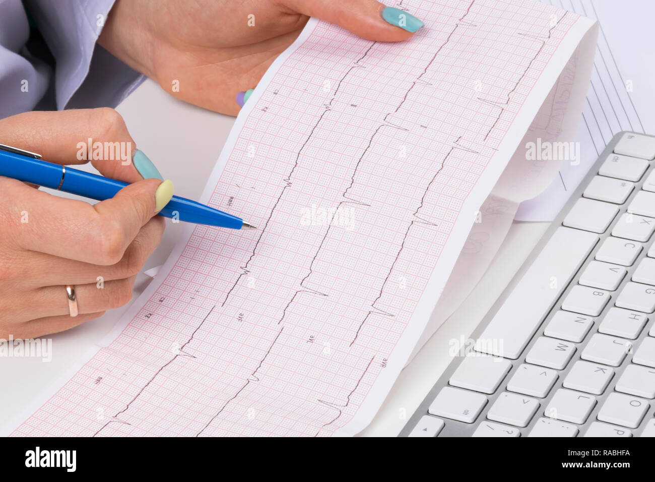Doctor workplace. Electrocardiogram, ecg in hand of a female doctor
