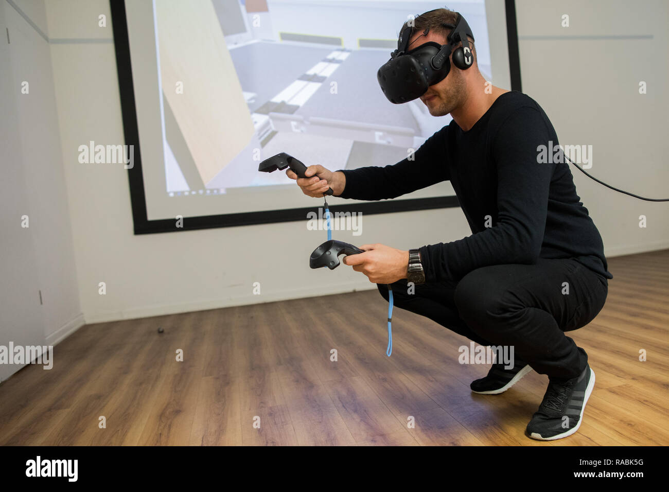 12 November 2018, North Rhine-Westphalia, Köln: Train attendant Daniel von Contzen practices the operation of a built-in lift at the doors of an ICE4 for wheelchair users during a training with Virtual Reality. Since 2018, virtual and augmented reality have been an integral part of Deutsche Bahn's training and further education program. (to dpa 'Realistic and secure: Companies rely on virtual reality training' from 03.01.2019) Photo: Rolf Vennenbernd/dpa Stock Photo