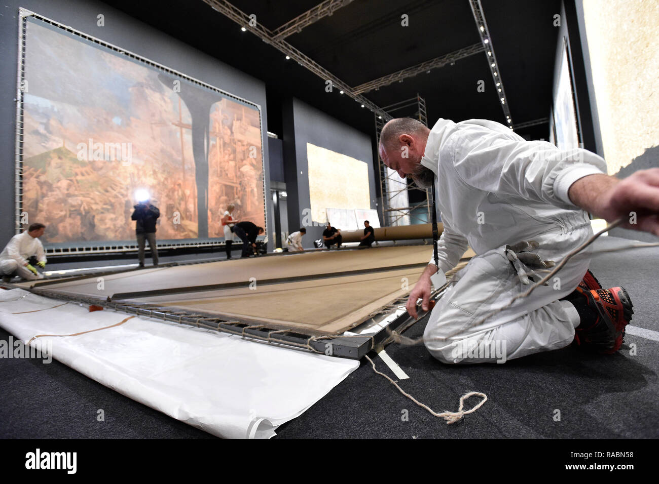 Brno, Czech Republic. 03rd Jan, 2019. Workers of the Prague City Gallery pack a part of The Slav Epic cycle of paintings by Czech Art Nouveau artist Alfons (Alphonse) Mucha (1860-1939), after the end of the 'Alfons Mucha - Two worlds' exhibition within the 'Re:publika' festival marking the 100th anniversary of the founding of Czechoslovakia, on January 3, 2019, in Brno, Czech Republic. On the background is seen painting named Defense of Sziget against the Turks by Nicholas Zrinsky. Credit: Vaclav Salek/CTK Photo/Alamy Live News Stock Photo