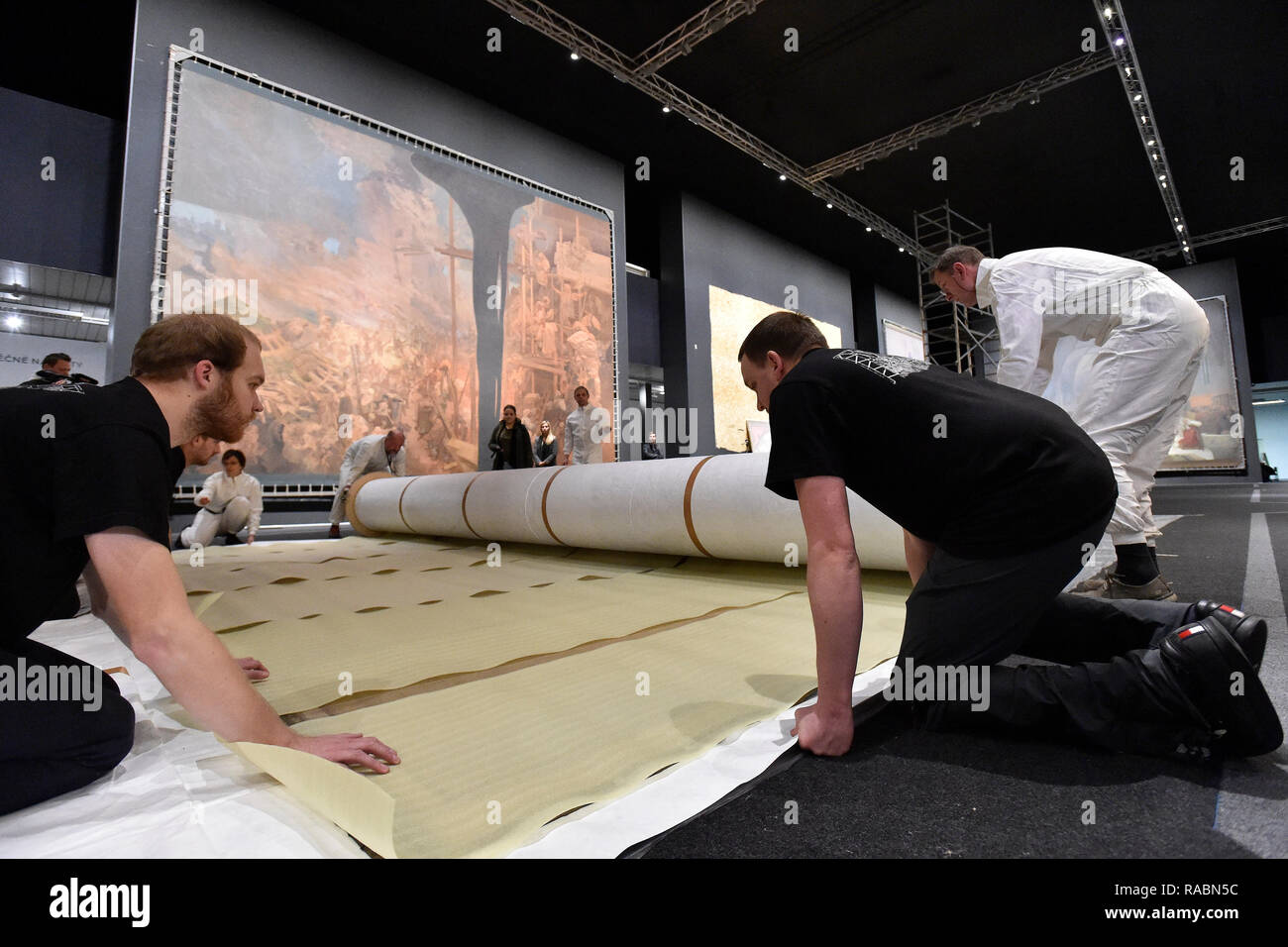 Brno, Czech Republic. 03rd Jan, 2019. Workers of the Prague City Gallery pack a part of The Slav Epic cycle of paintings by Czech Art Nouveau artist Alfons (Alphonse) Mucha (1860-1939), after the end of the 'Alfons Mucha - Two worlds' exhibition within the 'Re:publika' festival marking the 100th anniversary of the founding of Czechoslovakia, on January 3, 2019, in Brno, Czech Republic. On the background is seen painting named Defense of Sziget against the Turks by Nicholas Zrinsky. Credit: Vaclav Salek/CTK Photo/Alamy Live News Stock Photo