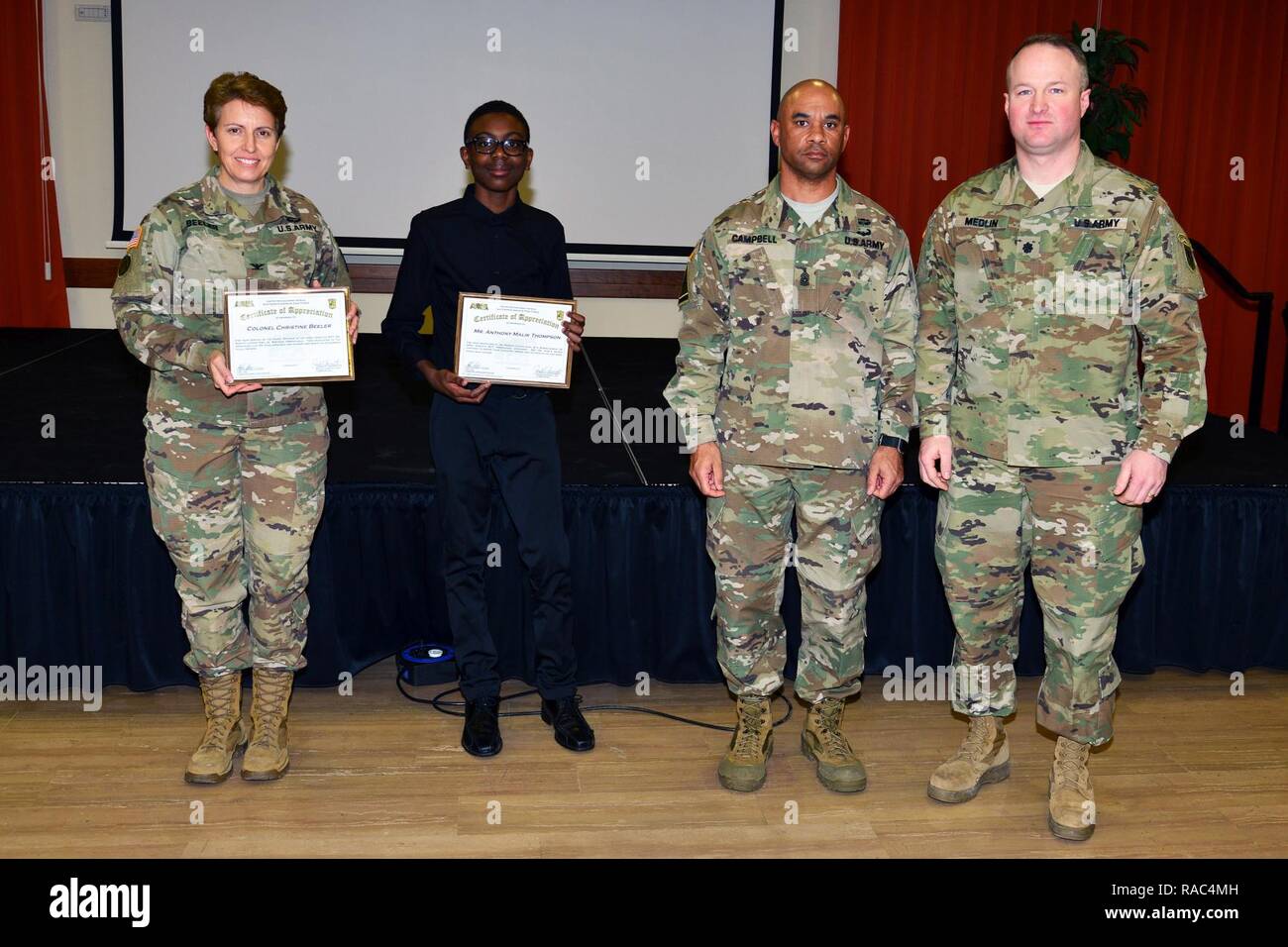 (From left), Colonel Christine A. Beeler, commander of the 414th Contracting Support Brigade, Mr. Anthony Malik Thompson of the Vicenza high school, Command Sgt. Maj. Birdel L. Campbell, Battalion Command Sergeant Major U.S. Army Africa and Lt. Col. Brett M. Medlin, Battalion Commander U.S. Army Africa, pose for a photo during award appreciation for Martin Luther King, Jr. Day, at Vicenza Military Community’s 2017 Observance Ceremony at Caserma Ederle, Vicenza, Italy, Jan. 10, 2017. Stock Photo