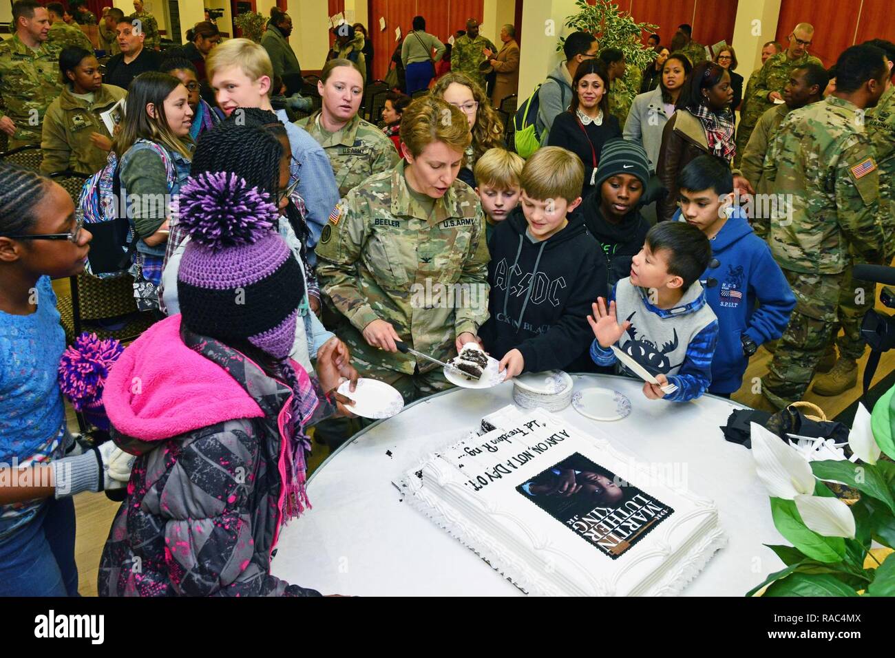 Colonel Christine A. Beeler, commander of the 414th Contracting Support Brigade, serves cake to children, during Martin Luther King, Jr. Day observance, at Vicenza Military Community’s 2017 Observance Ceremony at Caserma Ederle, Vicenza, Italy, Jan. 10, 2017. Stock Photo