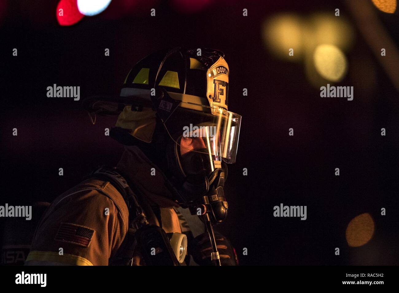 Airman 1st Class Jacob Molden, 23d Civil Engineer Squadron firefighter, looks towards a burning prop aircraft during nighttime, live-fire training, Jan. 10, 2017, at Moody Air Force Base, Ga. This training is an annual requirement for Moody firefighters and is just one of the ways they stay ready to protect people, property and the environment from fires and disasters. Stock Photo