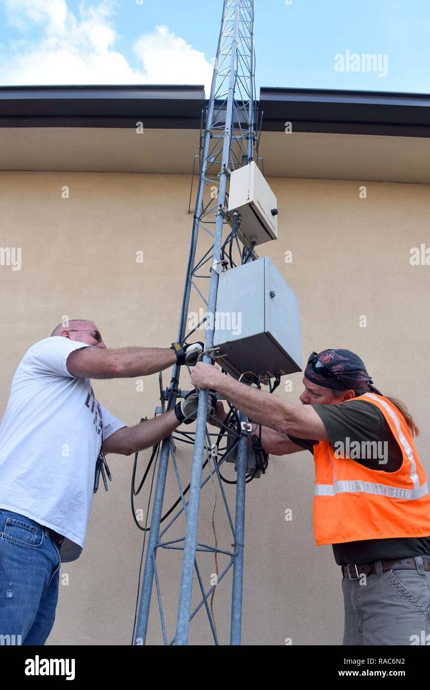 Bill Caskin (left) and Jeff Cheek, 78th Civil Engineering industrial mechanical controls mechanics, repair a fire signal transmitter on an antennae outside Bldg. 270. The transmitter sends signals to first responders on base that help pinpoint problem areas in the event of an emergency. Stock Photo